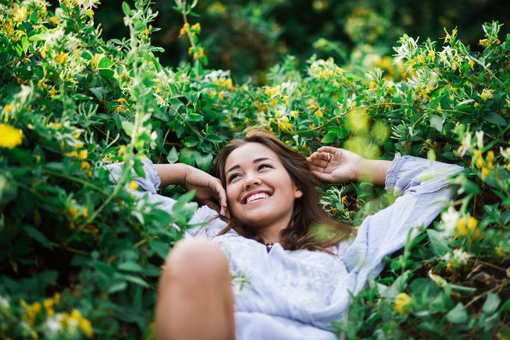 Harmonisk kvinna omgiven av blommiga växter